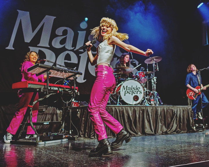 photo of Maisie Peters dancing on a stage.